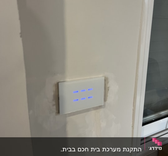מתג חכם עם תאורה כחולה על קיר